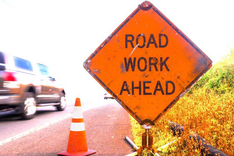 Road work ahead sign with fast car